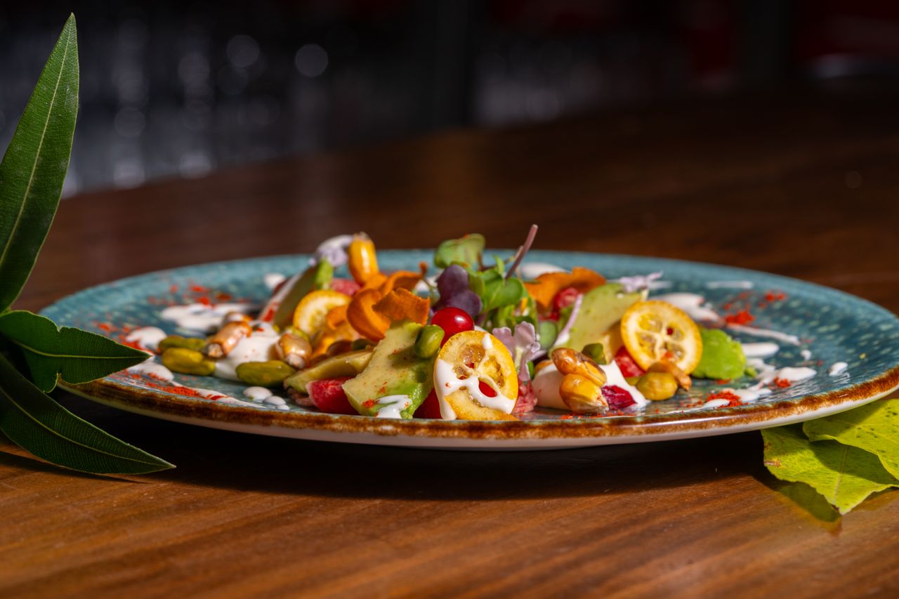 home-hero A vibrant gourmet salad with fresh ingredients artfully plated on a rustic dish.