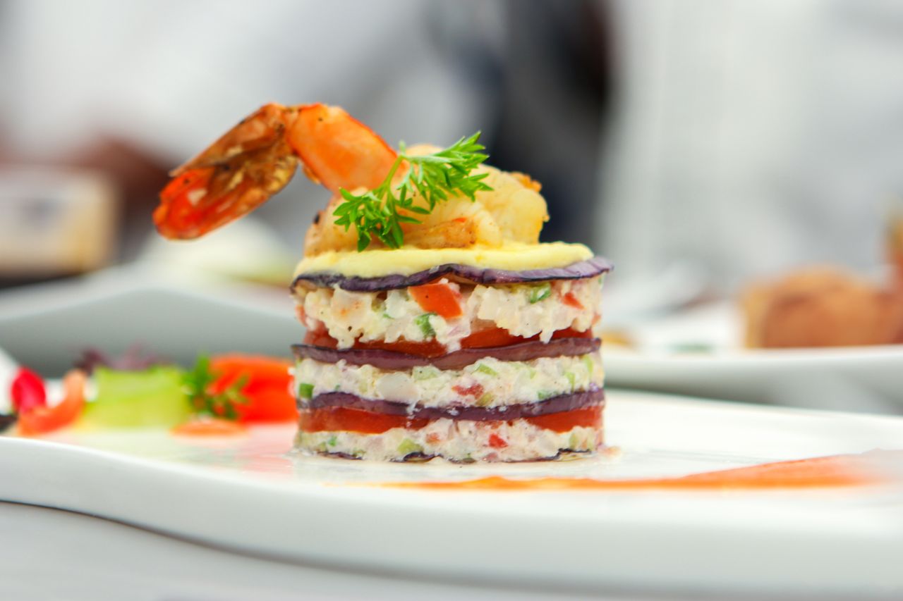services-05 Delicate layers of shrimp, vegetables, and garnish create a gourmet culinary masterpiece.