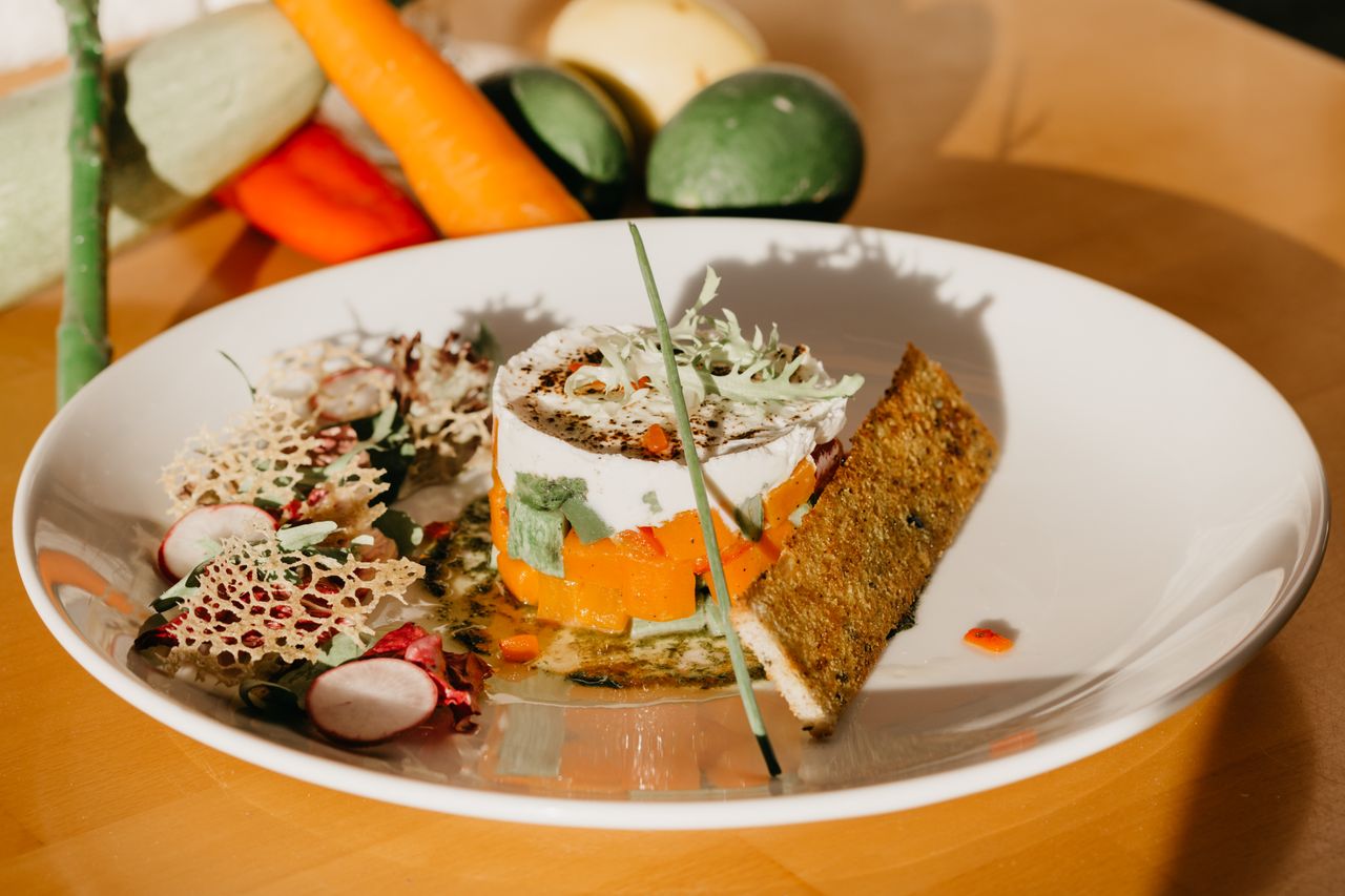 services-02 High angle of healthy vegetable tartar served on white ceramic plate with salad and crispy bread near scattered fresh ingredients in kitchen in sunlight
